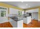 Well-lit kitchen featuring white cabinetry, an island with granite countertop, and hardwood floors at 345 Mentor Rd, Summerville, SC 29483