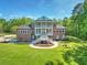 Aerial view of a grand brick house featuring a manicured lawn and a charming veranda at 349 Mentor Rd, Summerville, SC 29483