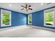 Bright blue bedroom featuring large windows, neutral carpet, and a ceiling fan at 349 Mentor Rd, Summerville, SC 29483