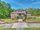 Elegant brick home featuring symmetrical design, manicured lawn, and beautiful landscaping at 349 Mentor Rd, Summerville, SC 29483