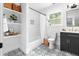 Stylish bathroom features patterned tile floors, tub with shower, modern vanity and shelves at 3683 Hilton Dr, Johns Island, SC 29455