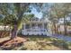 Charming two-story home featuring a welcoming front porch and gravel driveway surrounded by mature trees at 3683 Hilton Dr, Johns Island, SC 29455