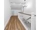 Hallway with wood floors, white railings, and modern chandelier at 3683 Hilton Dr, Johns Island, SC 29455