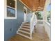 Inviting porch with a wood ceiling, a modern light fixture, white railings, and wooden steps at 3683 Hilton Dr, Johns Island, SC 29455
