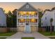 Charming two-story home features a double porch lit at sunset, with a well-manicured lawn at 3718 Sandy Gate Ln, Mount Pleasant, SC 29466