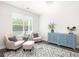 Bright sitting room with two pink chairs, blue cabinet and large window at 3718 Sandy Gate Ln, Mount Pleasant, SC 29466
