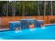 Beautiful pool with cascading waterfall feature, set against a backdrop of mature trees for added privacy at 3718 Sandy Gate Ln, Mount Pleasant, SC 29466