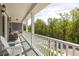 Charming covered porch with white railings, outdoor seating, and a view of lush greenery at 3718 Sandy Gate Ln, Mount Pleasant, SC 29466