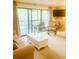Bright living room with sliding glass doors to porch, with a beige couch, table and decorative chair at 4262 Mariners Watch, Kiawah Island, SC 29455