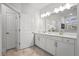 Bathroom features dual sinks with white cabinets and modern light fixtures above a large mirror at 4263 Hugh Bennett Dr, Johns Island, SC 29455