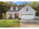 Charming exterior elevation showcasing a two-car garage, dormer windows and a inviting covered front porch at 4263 Hugh Bennett Dr, Johns Island, SC 29455