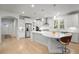 Bright, open kitchen boasts white cabinets, stainless appliances, and a large island with barstool seating at 4263 Hugh Bennett Dr, Johns Island, SC 29455