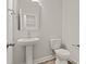 Modern powder room with pedestal sink, stylish mirror, and a sleek, water-efficient toilet at 503 Fiskdale Cir, Summerville, SC 29486