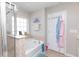 Bathroom featuring tub with shower and glass door, gray walls, window and towel rack at 5138 Preserve Blvd, Ladson, SC 29456