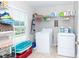 Practical laundry room with washer, dryer, wire shelves, and window providing natural light for convenience at 5138 Preserve Blvd, Ladson, SC 29456