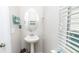 Elegant powder room with pedestal sink, oval mirror, and charming decorative touches by the window at 5138 Preserve Blvd, Ladson, SC 29456