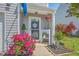 Inviting front porch adorned with vibrant pink flowers, a welcome sign, and a charming seating area at 531 Truman Dr, Goose Creek, SC 29445