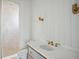 Bathroom with a shower behind glass, white walls, modern fixtures, and brass sconces at 546 Towles Crossing Dr, Johns Island, SC 29455
