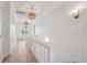 Hallway featuring white wainscoting, wood floors, and decorative sconces at 546 Towles Crossing Dr, Johns Island, SC 29455
