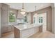 Bright, neutral kitchen with an island, marble countertops, and designer light fixtures at 546 Towles Crossing Dr, Johns Island, SC 29455