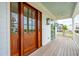 The well-lit porch features wood floors, lighting, fan, and views of nearby trees at 546 Towles Crossing Dr, Johns Island, SC 29455