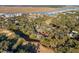 Discover picturesque homes nestled amidst lush trees and meandering waterways in this captivating aerial view, showcasing the neighborhood's charm at 764 Summerwind Cir, Edisto Beach, SC 29438