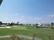Scenic golf course view with lush green fairways, water features, and homes, offering a perfect blend of recreation and residential charm at 764 Summerwind Cir, Edisto Beach, SC 29438