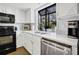 Bright kitchen with white cabinets, stainless steel appliances, and a large window at 764 Summerwind Cir, Edisto Beach, SC 29438