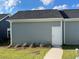 Side view of a home's exterior with gray siding, a white door, and a well-maintained lawn at 766 Blueway Ave, Summerville, SC 29486