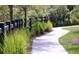 Scenic community path lined with lush greenery and a black fence at 766 Blueway Ave, Summerville, SC 29486