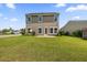 Expansive backyard with lush green grass, patio, and mature landscaping at 9652 Spencer Woods Rd, Ladson, SC 29456