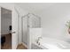 Bright white bathroom with bathtub, glass enclosed shower, and neutral tile flooring at 9652 Spencer Woods Rd, Ladson, SC 29456