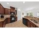 Well-lit kitchen with granite countertops, brown cabinets, and stainless steel appliances at 9652 Spencer Woods Rd, Ladson, SC 29456