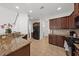 Well-appointed kitchen with granite countertops, dark wood cabinets, and stainless steel appliances at 9652 Spencer Woods Rd, Ladson, SC 29456