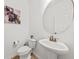 Bright powder room with pedestal sink, oval mirror, and decorative art at 9652 Spencer Woods Rd, Ladson, SC 29456
