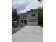 Charming two-story home with light blue siding, a front porch, and a large driveway leading to a two-car garage at 971 Beehive Rd, Awendaw, SC 29429