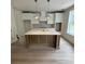 Modern kitchen features a center island with marble countertop, custom cabinetry, and stylish pendant lighting at 971 Beehive Rd, Awendaw, SC 29429