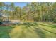 Spacious backyard with an in-ground pool, patio, and lush green lawn surrounded by mature trees at 1010 Deep Gap Rd, Ridgeville, SC 29472