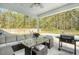 Backyard patio featuring outdoor seating, a grill, a view of the pool and a serene wooded backdrop at 1010 Deep Gap Rd, Ridgeville, SC 29472