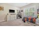 This bedroom boasts neutral walls, carpet, a ceiling fan, bright window, and wooden dresser, ensuring a cozy and inviting atmosphere at 1010 Deep Gap Rd, Ridgeville, SC 29472