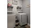 Functional laundry room with modern washer and dryer, shelving, and decorative wallpaper at 1010 Deep Gap Rd, Ridgeville, SC 29472