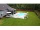 Aerial view of backyard pool with patio, seating, and a well-maintained lawn area at 1010 Deep Gap Rd, Ridgeville, SC 29472