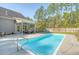 Inviting in-ground pool with patio and lounge area surrounded by a wooded yard and fence at 1010 Deep Gap Rd, Ridgeville, SC 29472
