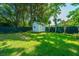 Lush green backyard featuring a storage shed, enclosed by a dark fence and mature trees at 1011 Ashley Ave, Charleston, SC 29403