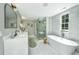 Bright bathroom featuring double sinks, soaking tub, glass shower, and elegant tile work at 1011 Ashley Ave, Charleston, SC 29403