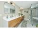 Bright bathroom featuring double sinks, frameless shower, and soaking tub area at 1011 Ashley Ave, Charleston, SC 29403