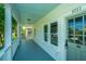 Inviting front porch with calming blue floors and ceiling offering a peek into the neighborhood at 1011 Ashley Ave, Charleston, SC 29403