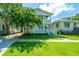 Charming two-story home with a well-manicured front yard and double porches on a sunny day at 1011 Ashley Ave, Charleston, SC 29403