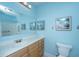 Bathroom featuring blue walls, wood vanity, and framed beach-themed prints at 1022 Basildon Rd, Mount Pleasant, SC 29466