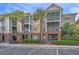Inviting condo exterior with screened porches, brick accents, and palm trees at 1022 Basildon Rd, Mount Pleasant, SC 29466